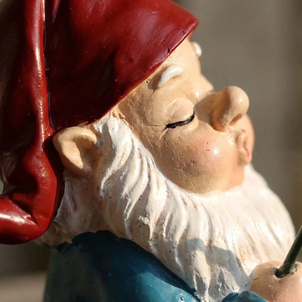 Schlafender Angelzwerg mit Angelrute auf Topfkante sitzend